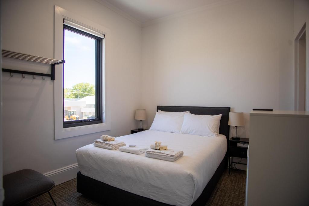 ein Schlafzimmer mit einem Bett mit zwei Tabletts drauf in der Unterkunft The Albion Hotel in Cootamundra