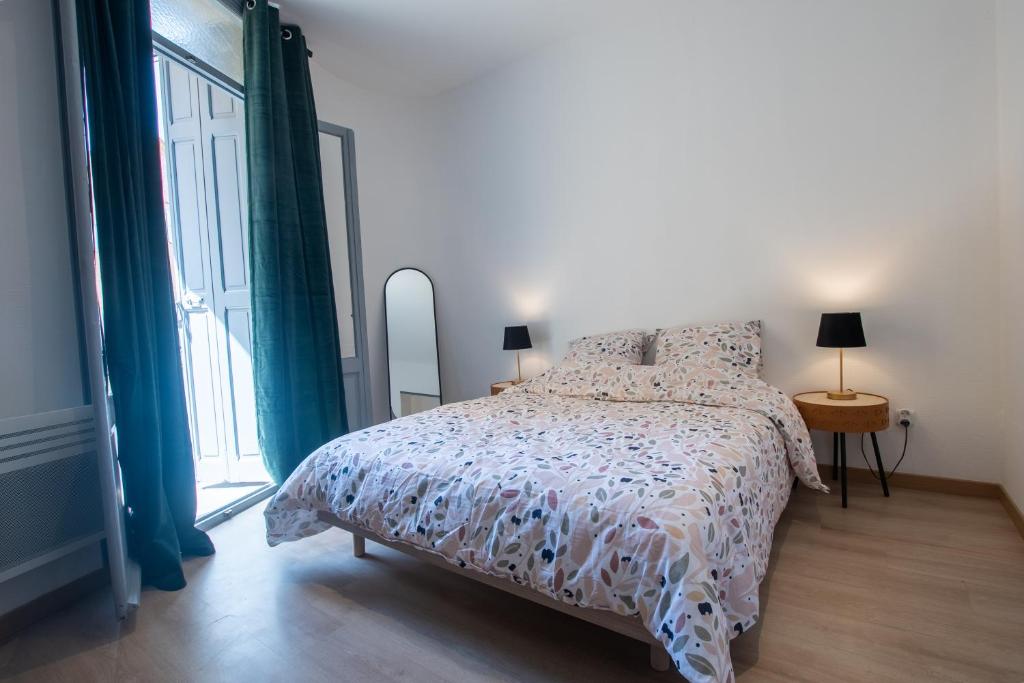 a bedroom with a bed and a large window at Appartement moderne et élégant quartier Saint-Jean Perpignan in Perpignan