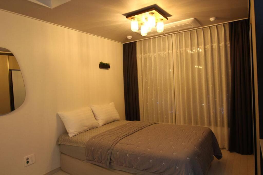 Ash Mellow في دايغو: غرفة نوم صغيرة بها سرير ونافذة