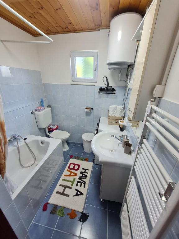 a bathroom with a sink and a toilet and a tub at Kuća za odmor Čanić gaj in Gospić