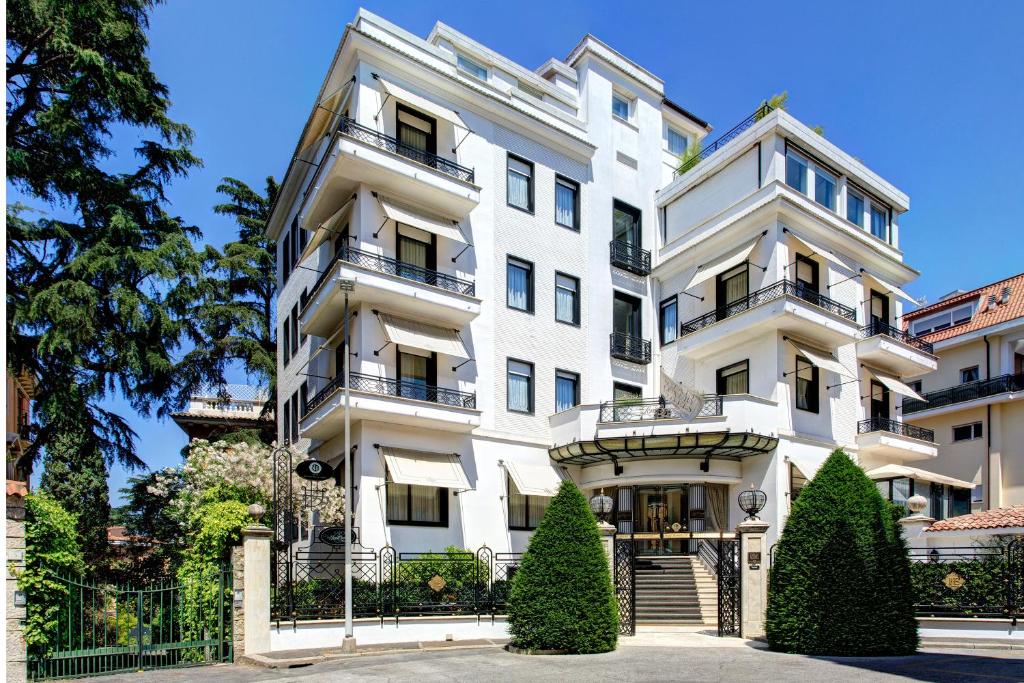 - un bâtiment blanc avec 2 balcons dans l'établissement Hotel Lord Byron - Small Luxury Hotels of the World, à Rome