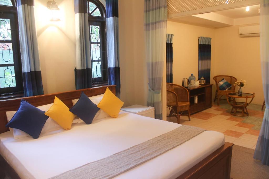 una camera da letto con un letto con cuscini blu e gialli di Airport Gateway Residence a Negombo