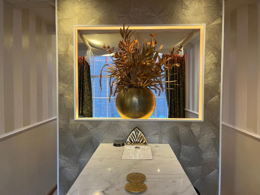 a table with a mirror and a vase with a plant at The Enlightened House Luxury Suites in Amsterdam