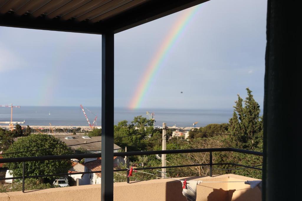 a rainbow over the ocean from a balcony at Estaque Cozy nest with a magical view of the sea in Marseille