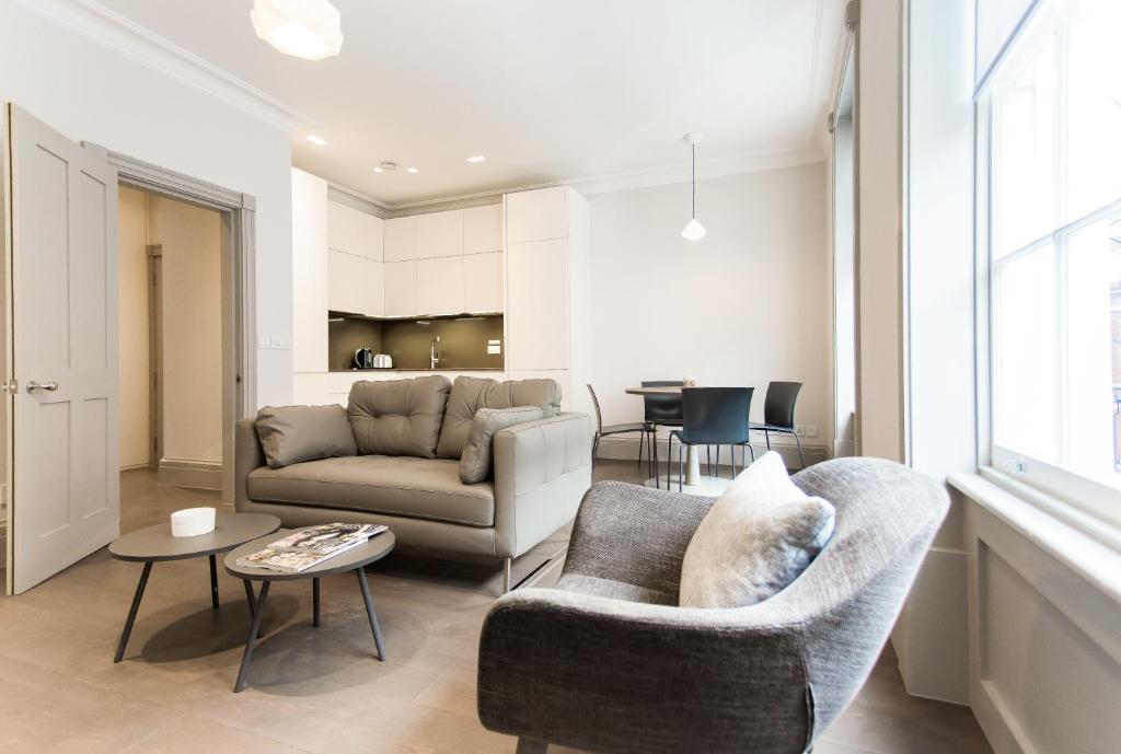 a living room with a couch and chairs and a table at Soho Luxury 1 Bedroom Apartment by Concept Apartments in London