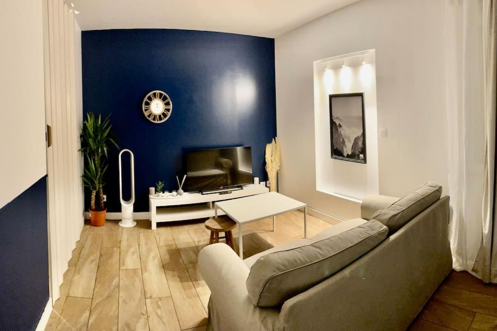 a living room with a couch and a table at Appartement studio in Villeurbanne