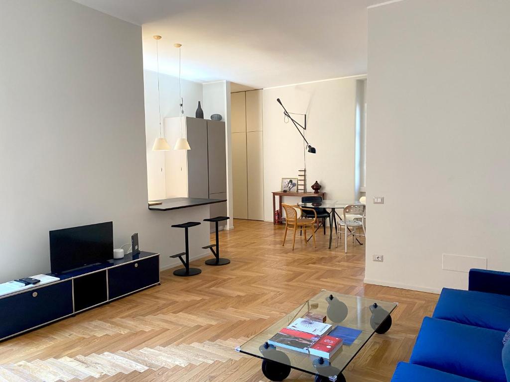 een woonkamer met een blauwe bank en een tafel bij Kibilù - Via Braga - Stazione Centrale in Milaan