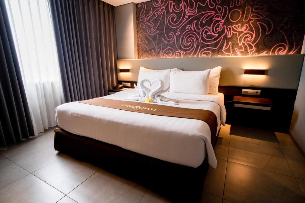 Postel nebo postele na pokoji v ubytování Midtown Hotel Samarinda