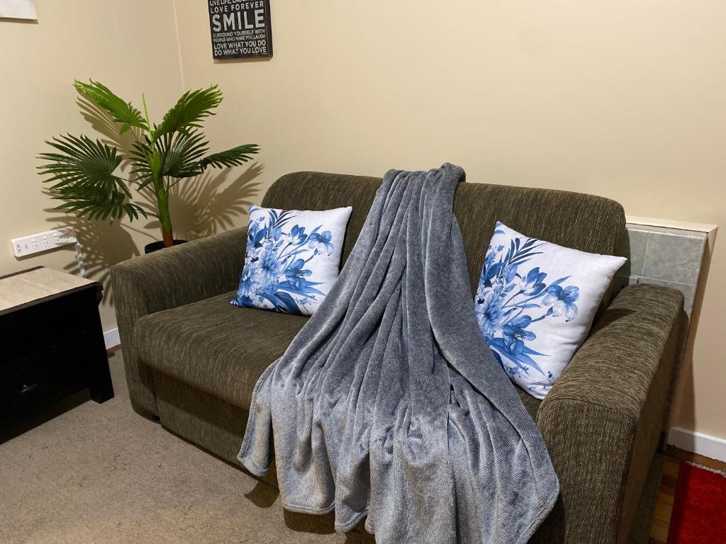a blanket on a couch in a living room at The Cozy Hutt Home in Upper Hutt