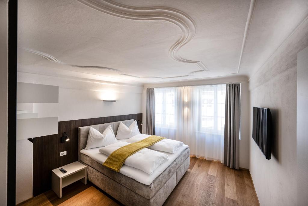 a bedroom with a bed and a large window at Odilia - Historic City Apartments - center of Brixen, WLAN and Brixencard included in Bressanone