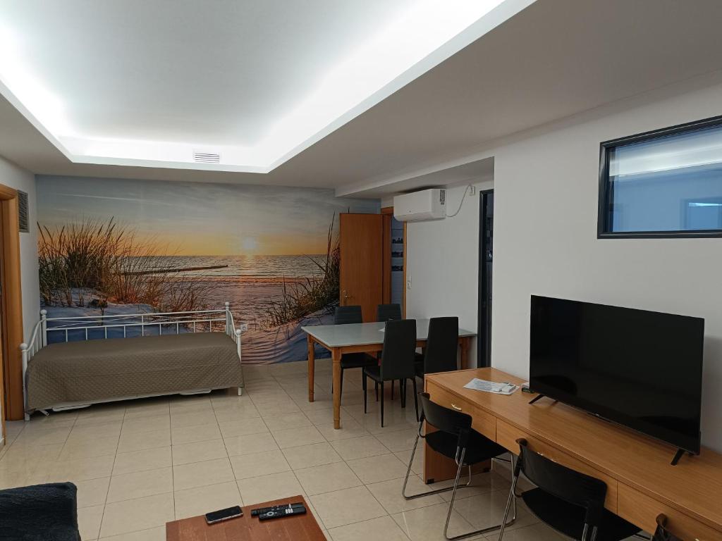 ein Wohnzimmer mit einem Flachbild-TV und einem Tisch in der Unterkunft Αρέθουσα sous sol 60 τμ υπόγειο διαμέρισμα in Chalkida