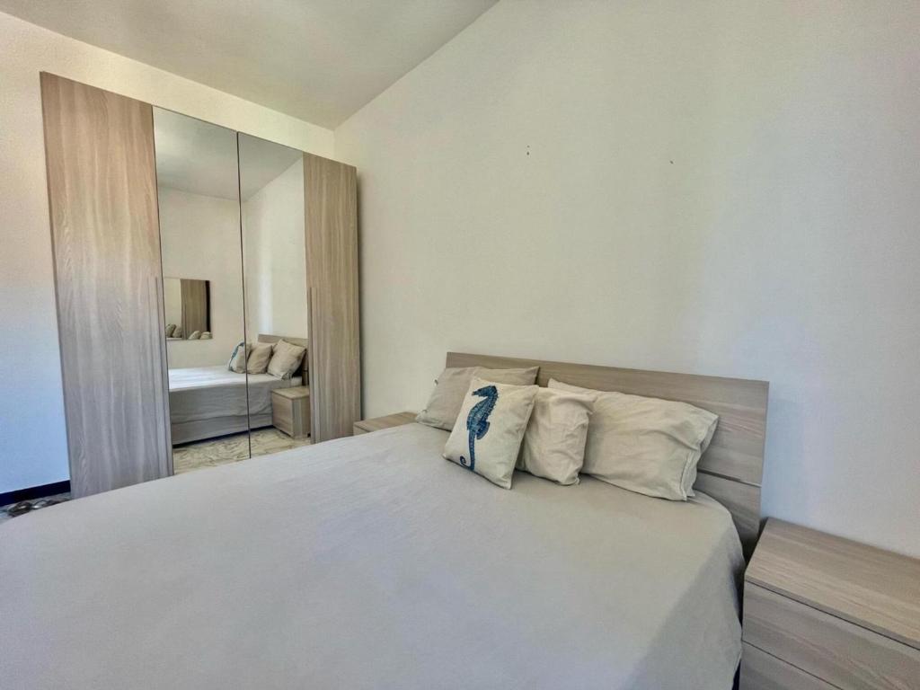 een slaapkamer met een groot wit bed met kussens bij Petit Bijou a Finale Ligure in Finale Ligure
