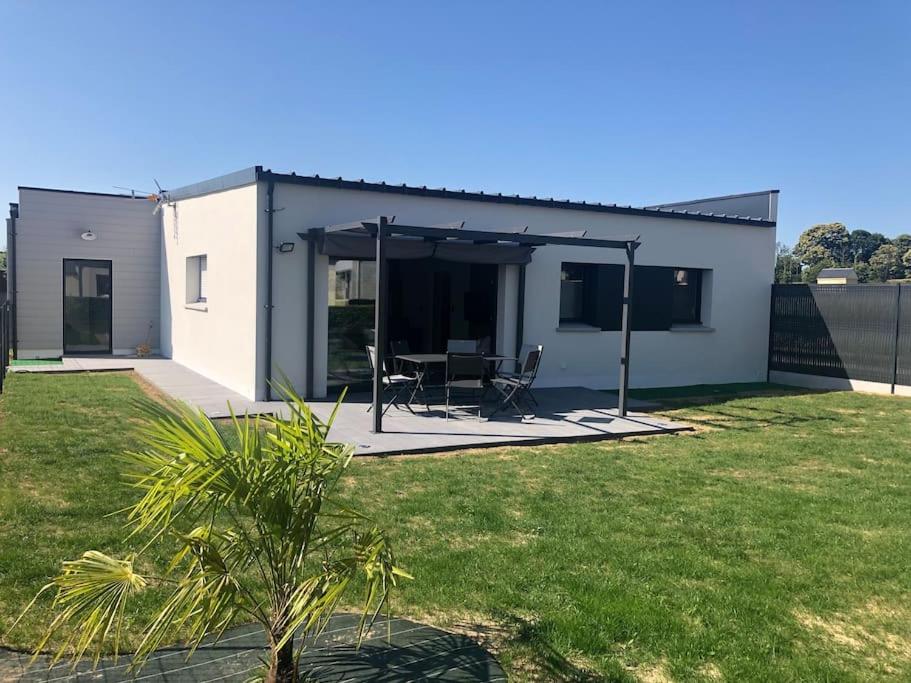 une maison avec un patio avec une table et des chaises dans l'établissement Location saisonnière Maen Roch, à Les Portes du Coglais