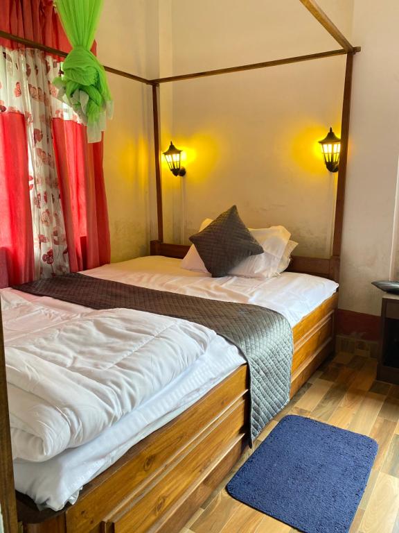 Annapurna Homestay في Chālsa: غرفة نوم بسريرين وسجادة زرقاء