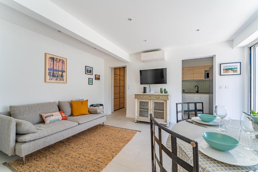 un salon avec un canapé et une table dans l'établissement Nathaniel - Appt terrasse 5 min de la plage, à Arcachon