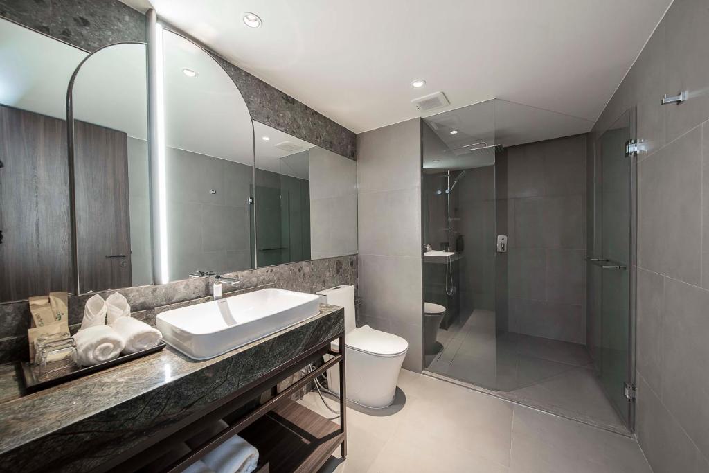A modern bathroom with a vessel sink, toilet and enclosed glass shower.