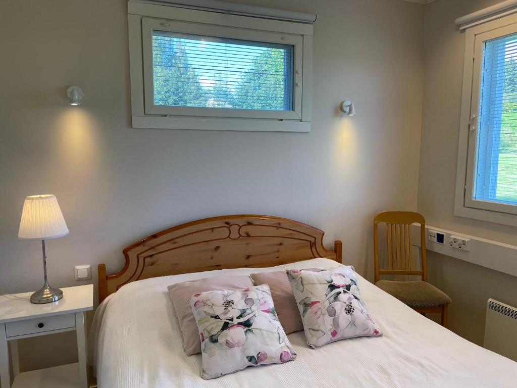 um quarto com uma cama com duas almofadas e uma janela em Puuppola Kotikoivu 