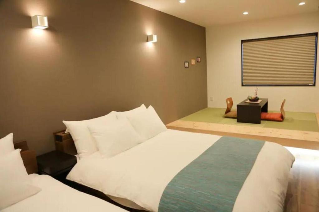 a bedroom with a large white bed and a window at KYOTO STATION HOUSE in Kyoto