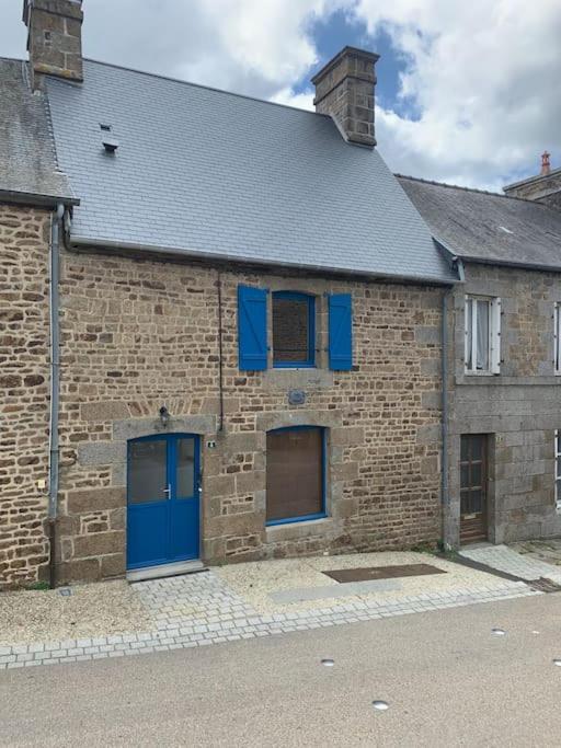 un ancien bâtiment en briques avec des portes et des fenêtres bleues dans l'établissement Location saisonnière à Montours, à Montours