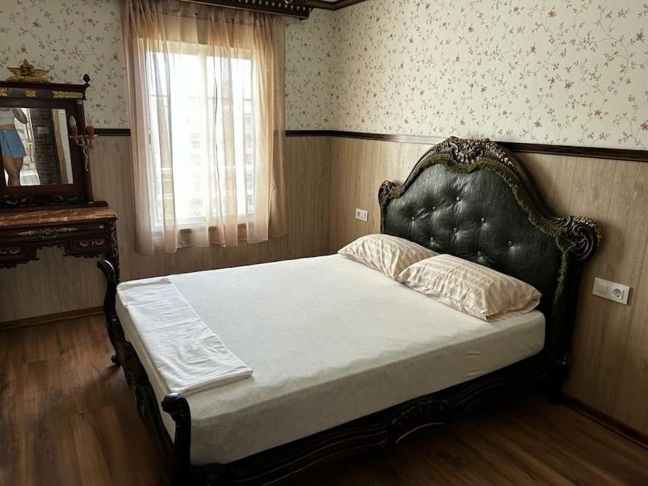 a bedroom with a bed with a headboard and a window at Luxury art Apartamenty in Pineda de Mar