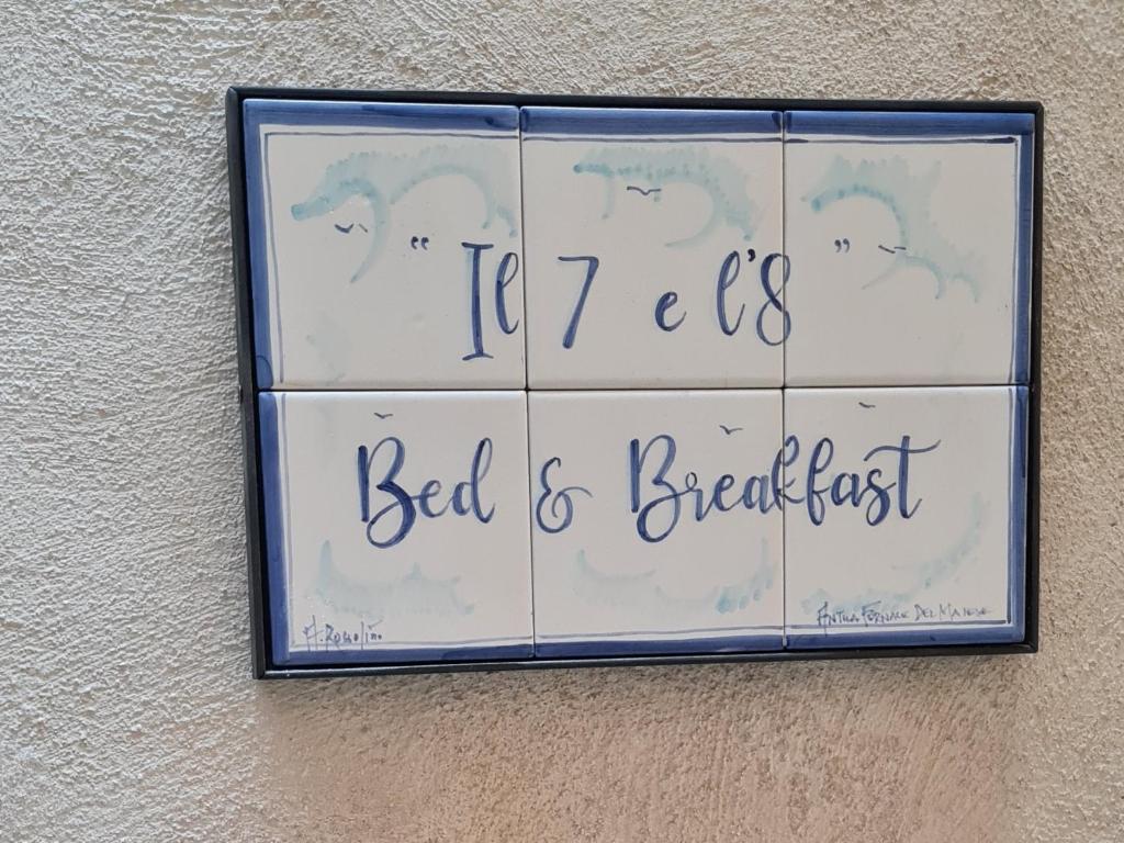 um sinal que lê cama e pequeno-almoço pendurado numa parede em Il sette e l'otto em Caiazzo