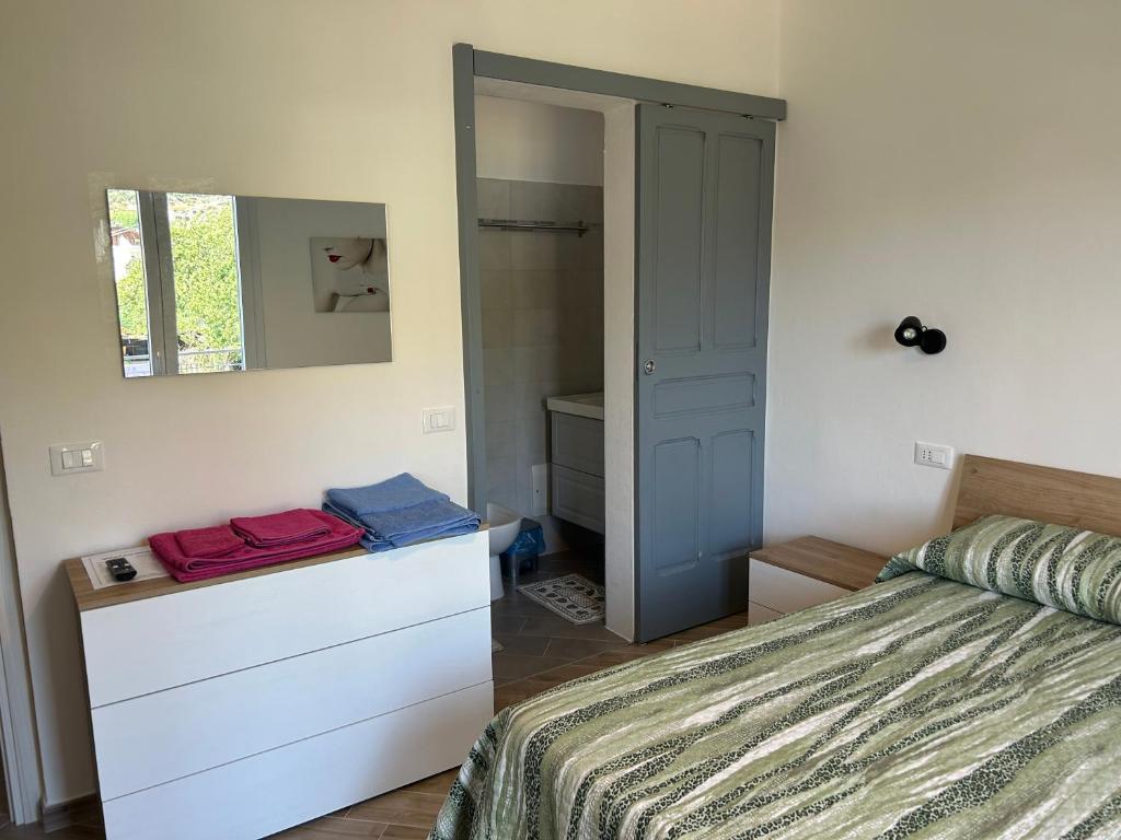 ein Schlafzimmer mit einem Bett mit einer Kommode und einem Spiegel in der Unterkunft Casa Marisa in Camporosso