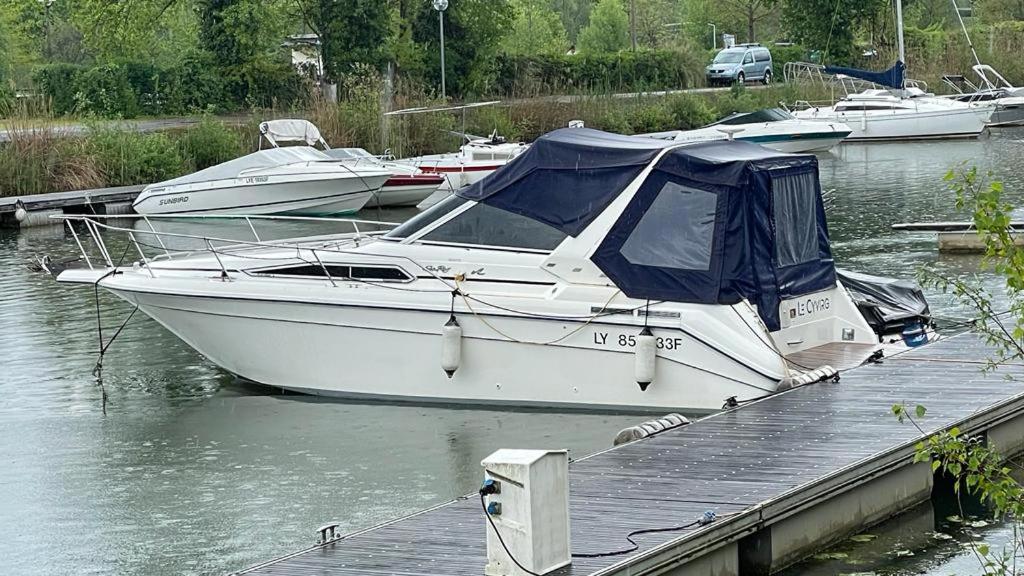 a white boat is docked at a dock at Le Cyvirg in Viviers-du-Lac