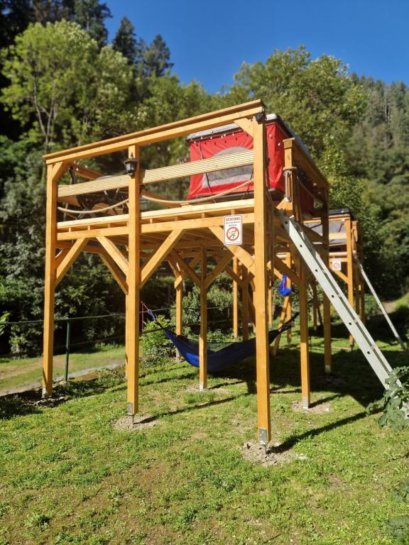 a wooden play structure with a slide in a park at Dachzelt Cochem in Cochem
