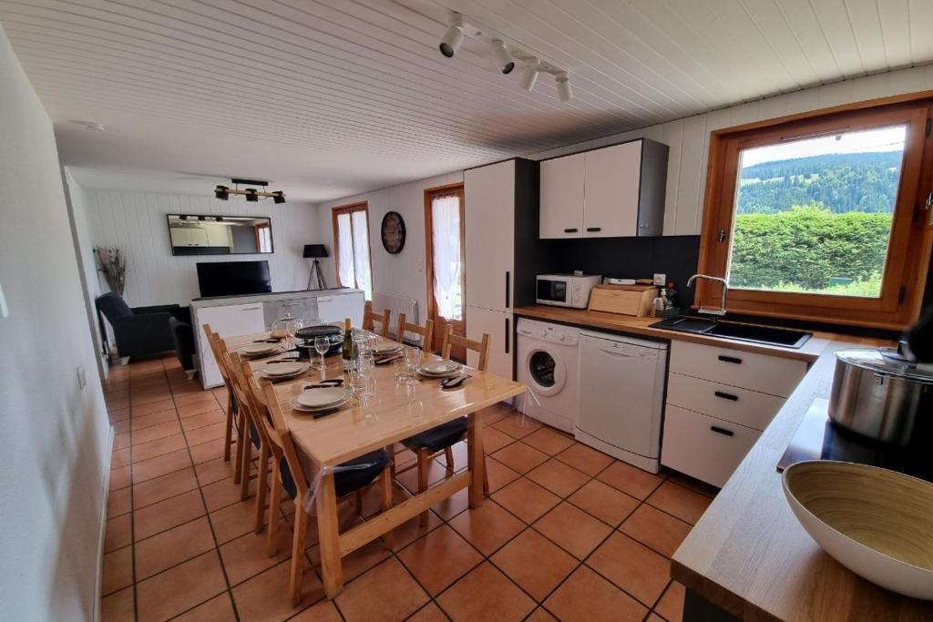 雷魯斯的住宿－Le Petit Bois，厨房配有桌椅和桌子。