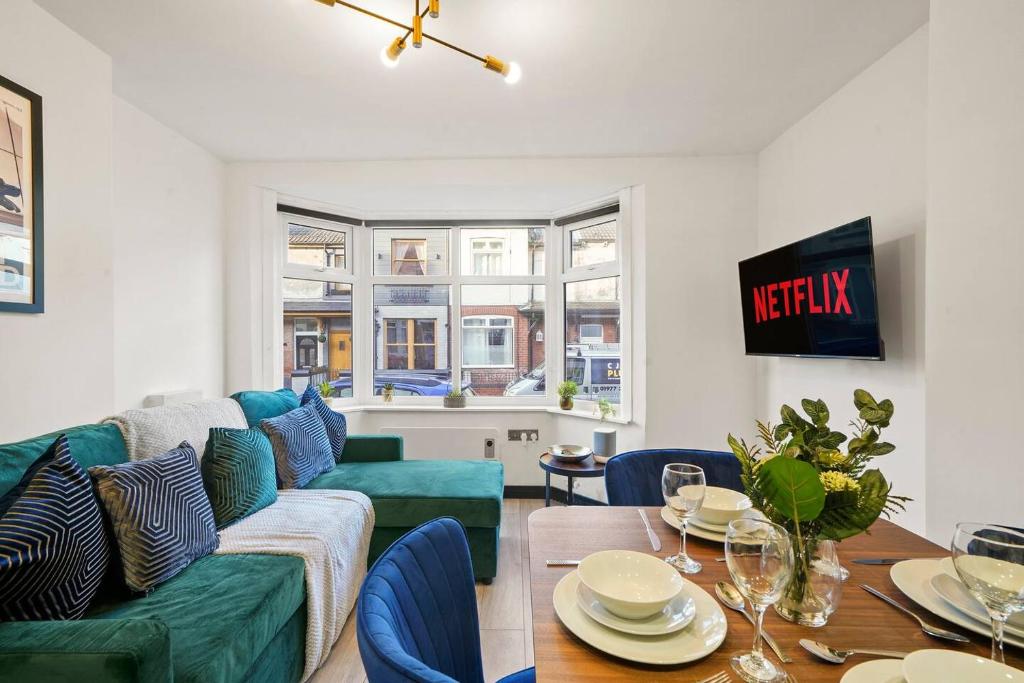 a living room with a green couch and a table at Stylish Yorkshire Apartment - Sleeps 5 in Castleford