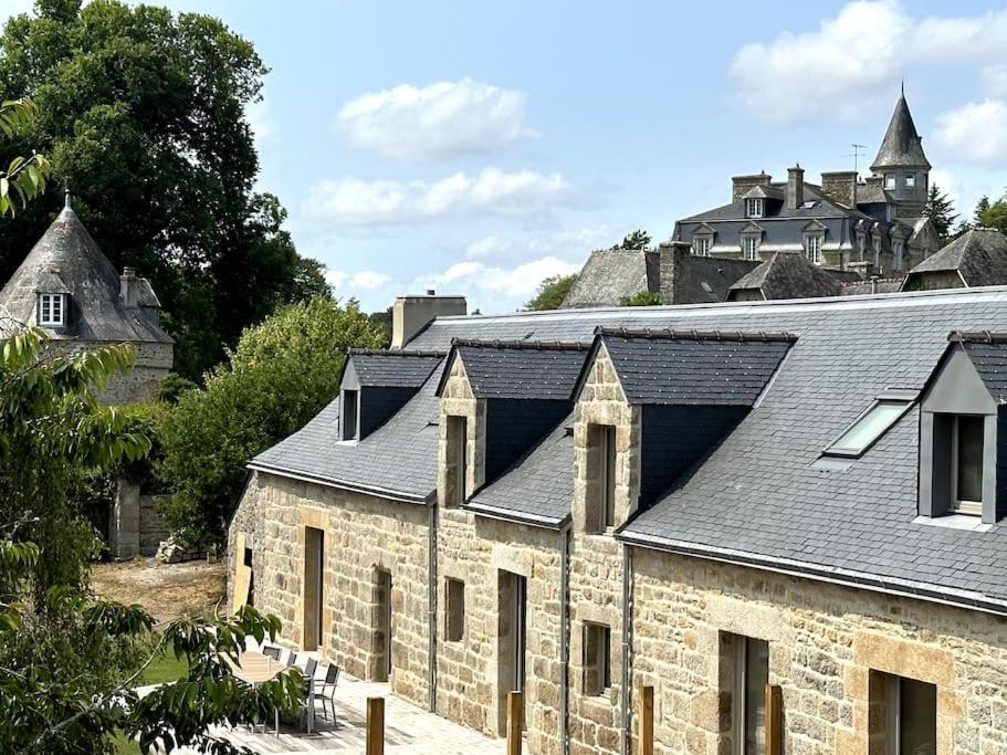 un ancien bâtiment en pierre avec un château en arrière-plan dans l'établissement Magnifique longère au calme de Kerminaouet, à Trégunc