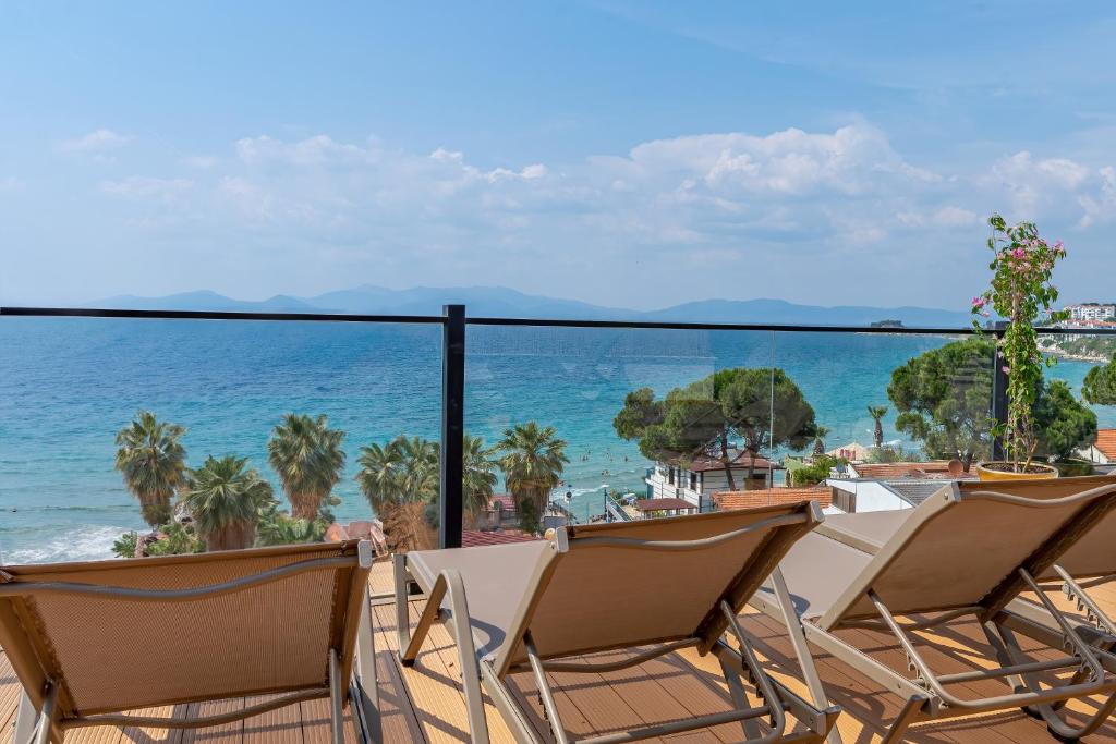 a balcony with chairs and a view of the ocean at Rosy Suites Hotel in Kuşadası