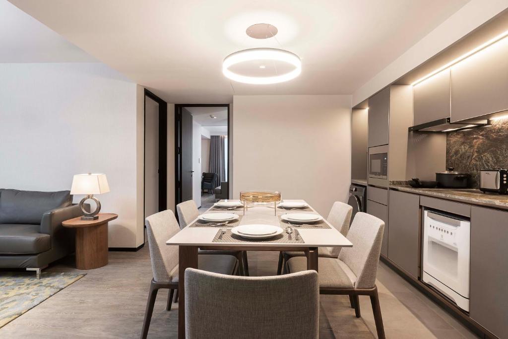 A suite dining and kitchen area with a six-seat table beside a compact living space.