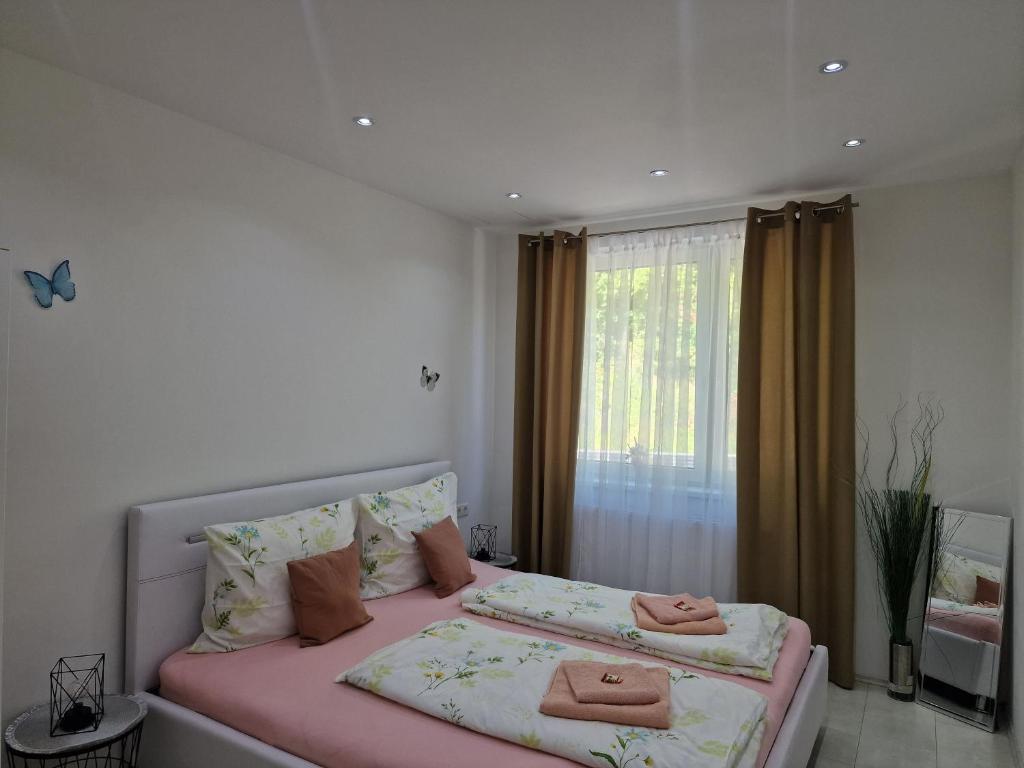 Deea Apartment في Schottwien: غرفة نوم بسريرين مع شراشف وردية ونافذة