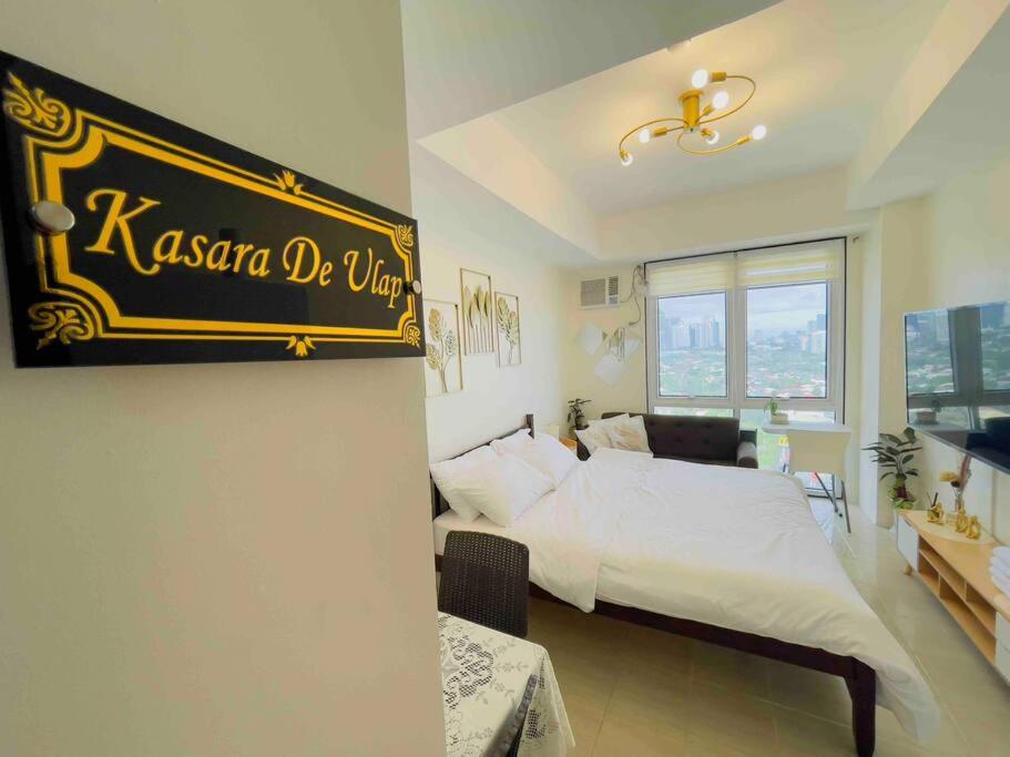 a bedroom with a bed and a sign on the wall at Kasara De Ulap BEST Staycation - 25th Floor City View - Pool & Fast Wi-Fi in Manila