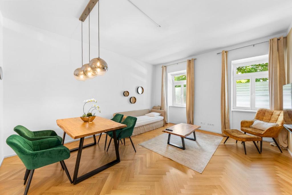 een woonkamer met een tafel en stoelen en een bank bij Vienna Chic Residences #Suite 2 in Wenen