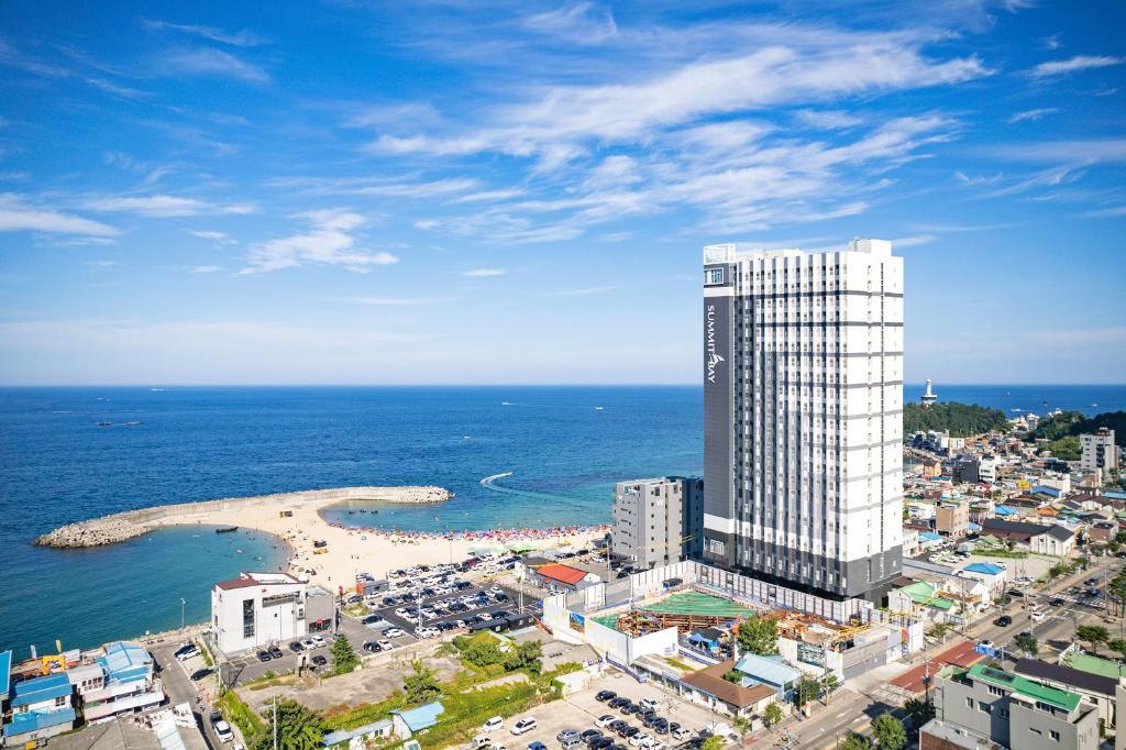 a tall building next to a beach next to the ocean at Urbanstay Sokcho Deungdae Beach in Sokcho