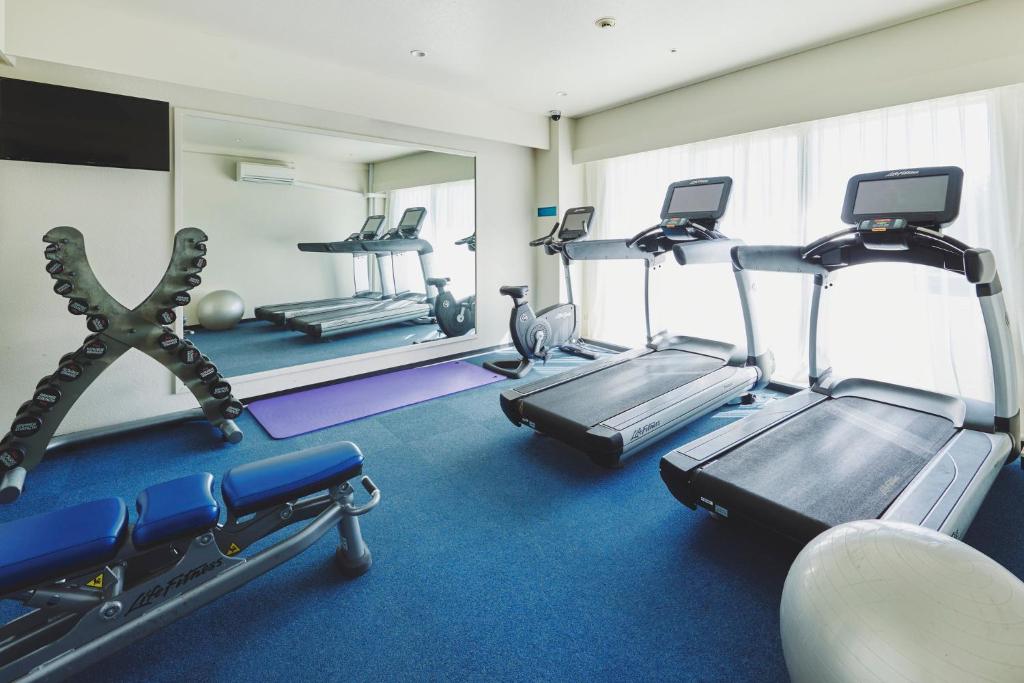 a gym with treadmills and machines in a room at ANA InterContinental Manza Beach Resort by IHG in Onna
