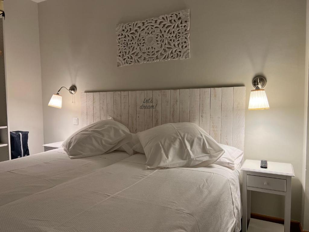 a bedroom with a white bed with two pillows at Aljara Corredera in Córdoba