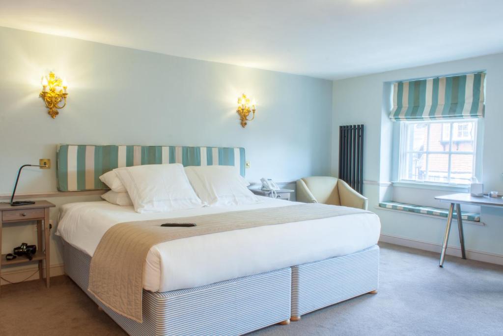 een slaapkamer met een groot bed in een kamer bij The Salutation Inn in Topsham