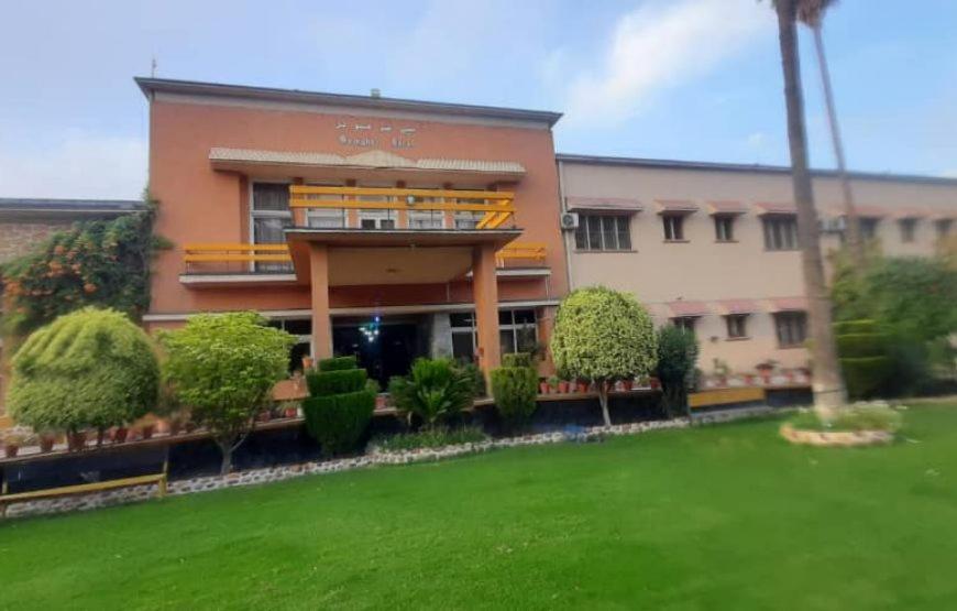 a building with a green lawn in front of it at Spinghar Royal Hotel in Jalalabad 