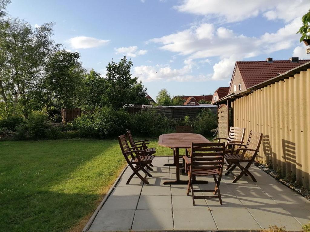 eine Terrasse mit einem Tisch und Stühlen im Hof in der Unterkunft NEU! Ferienhaus NordseeGlück in Dornum