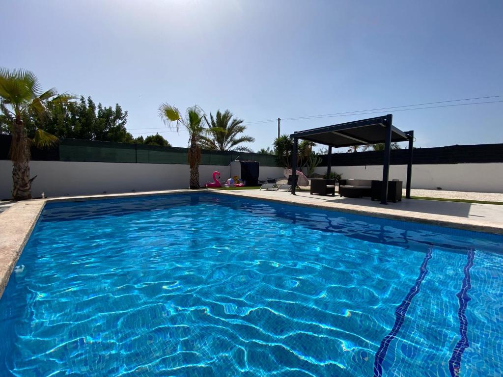 a large swimming pool with blue water at Villa Gerudo in Crevillente