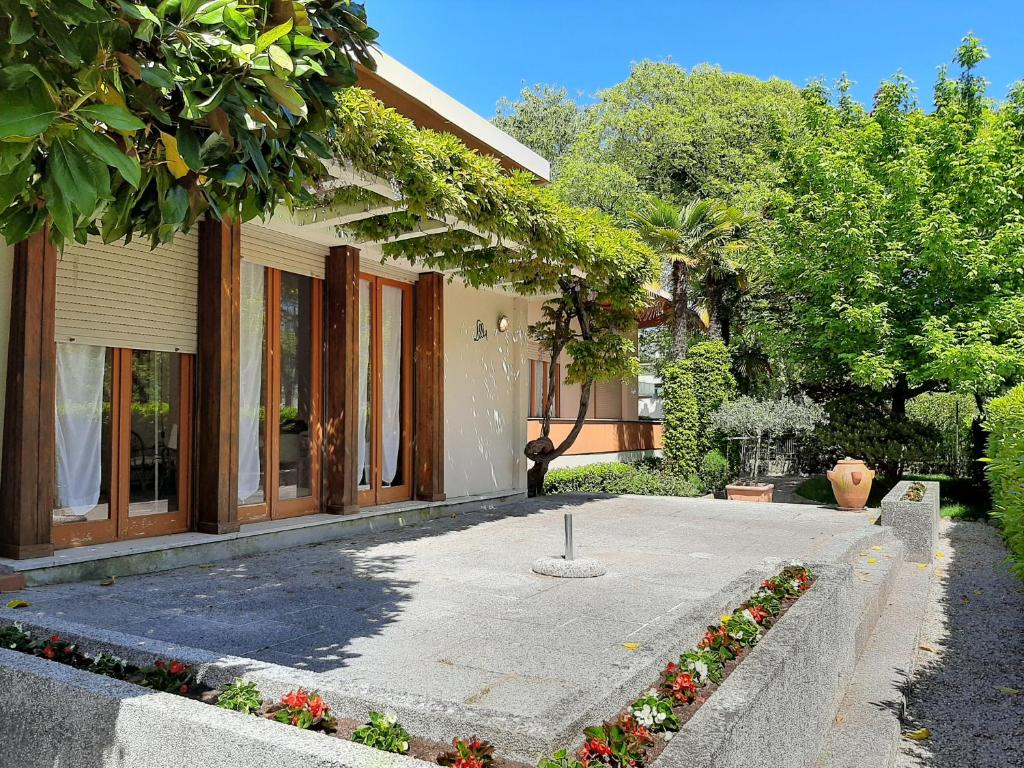 a house with a courtyard with flowers in front of it at Villa Lilly in Grado