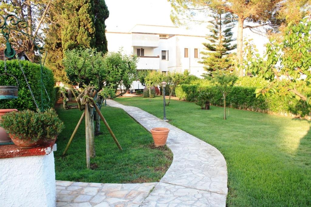 un jardin avec une passerelle dans la pelouse dans l'établissement B&B Verdegiada, à Brindisi