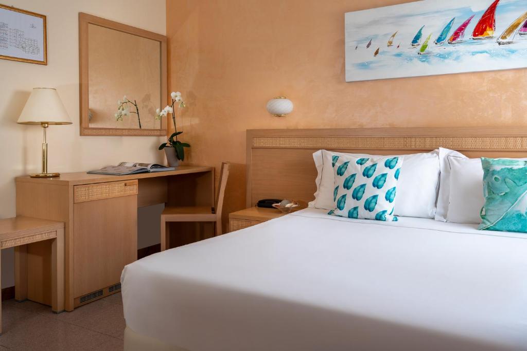 a bedroom with a bed and a desk and a bed at Corallo Wellness Hotel in Diano Marina