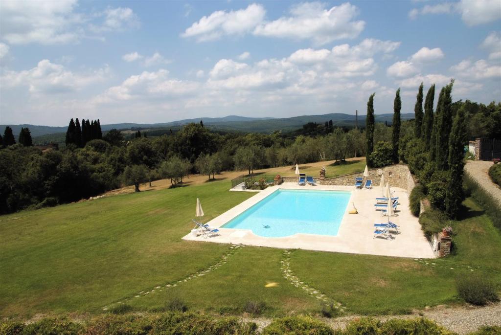 eine Luftansicht auf ein großes, grünes Feld mit einem Pool in der Unterkunft Residenza d'Epoca Il Cassero in Lucignano