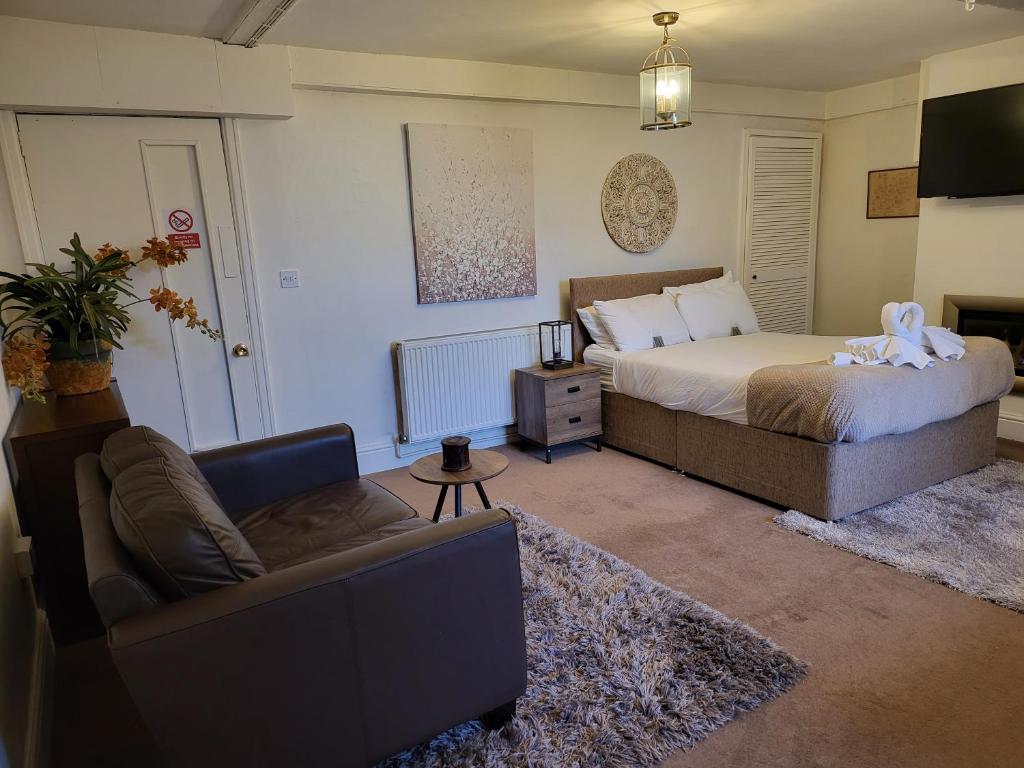a bedroom with a bed and a couch and a tv at Seaside Flat with Fast WiFi in Scarborough