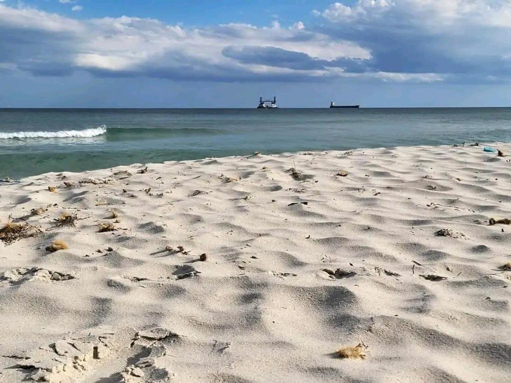 plaża z odciskami stóp w piasku i oceanie w obiekcie Appartement S2 Kantaoui vue mer w mieście Port El Kantaoui