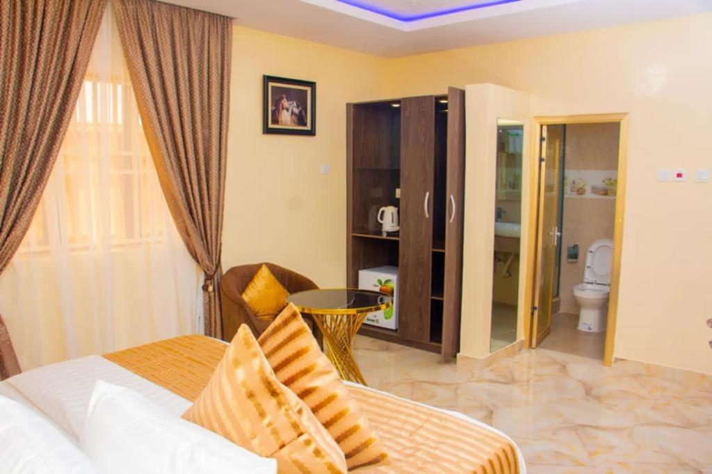 a bedroom with a bed and a bathroom at ERiTH APARTMENT & SUITES in Ikeja